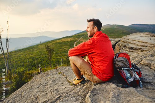 Man sitting on rock enjoying the view during hiking trip photo