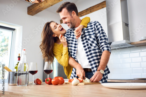 Affectionate couple in kitchen, preparing spaghetti toghether photo