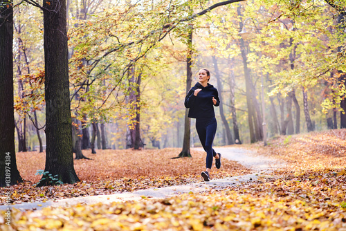 Young woman jogging in autumn forest © tunedin