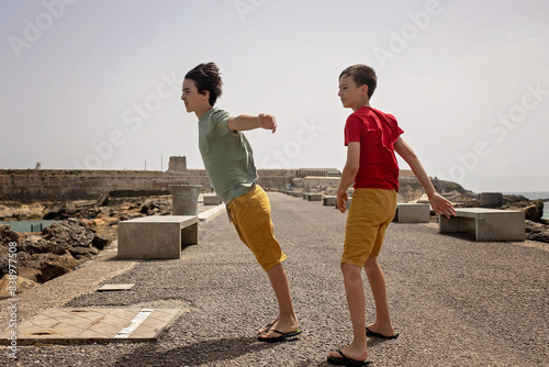 Cute child from european amily, visiting the most south point of Europe, Tarifa in Spain. Heavy wind blowing photo
