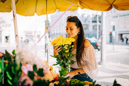 Obraz na płótnie Young woman smelling bouquet of flowers at flower shop w salonie