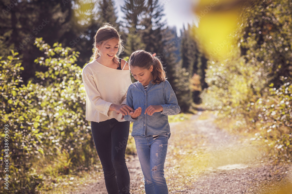 Two sisters walking on forest path Two sisters walking on forest path