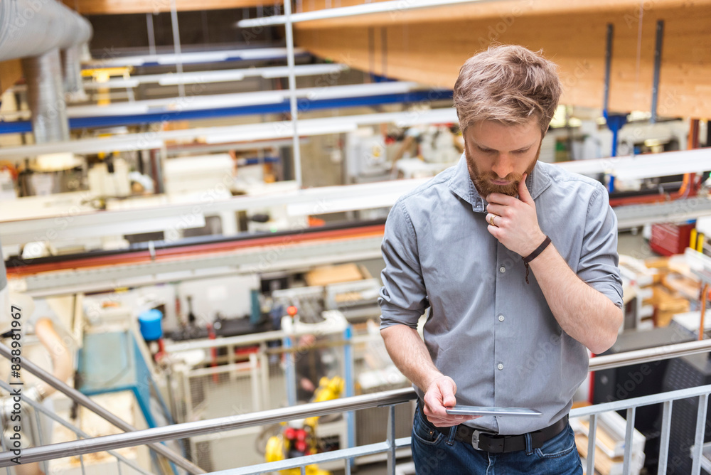Businessman using tablet in modern factory Businessman using tablet in modern factory