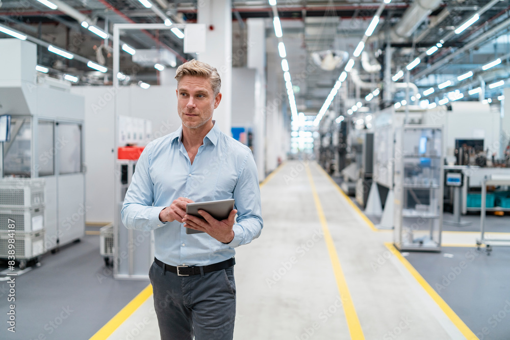 Businessman using tablet in a modern factory