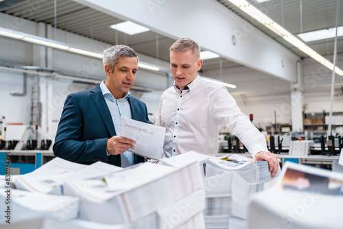 Obraz na płótnie Two businessmen discussing paper in a factory w salonie