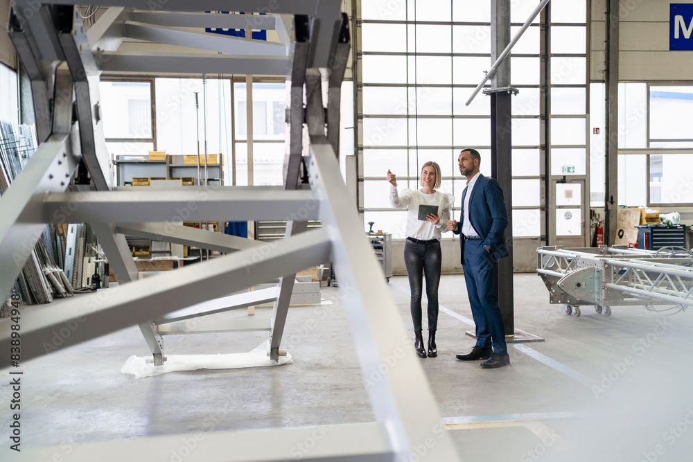 Businessman and young woman talking in a factory