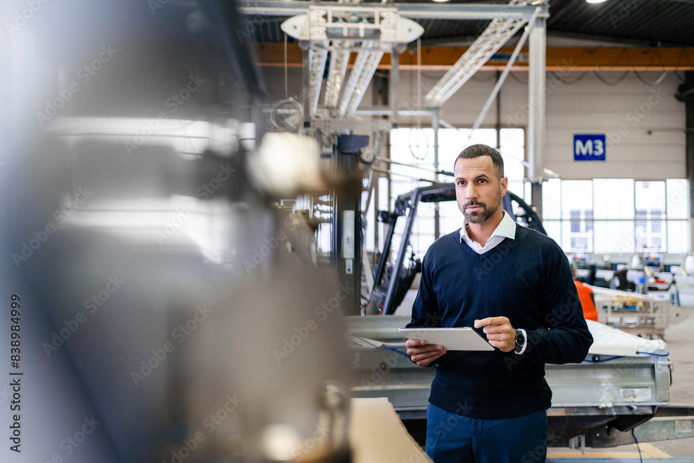 Businessman using tablet in a factory