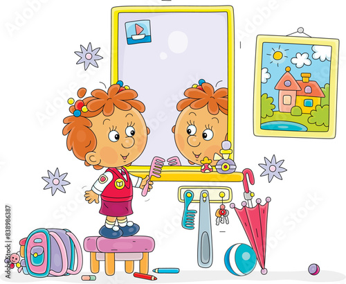Funny little girl combing her hair in front of a mirror in a hallway with a picture on a wall, vector cartoon illustration isolated on white