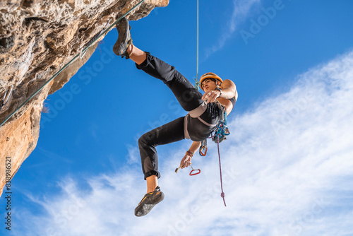 Female climber abseiling from rock face photo