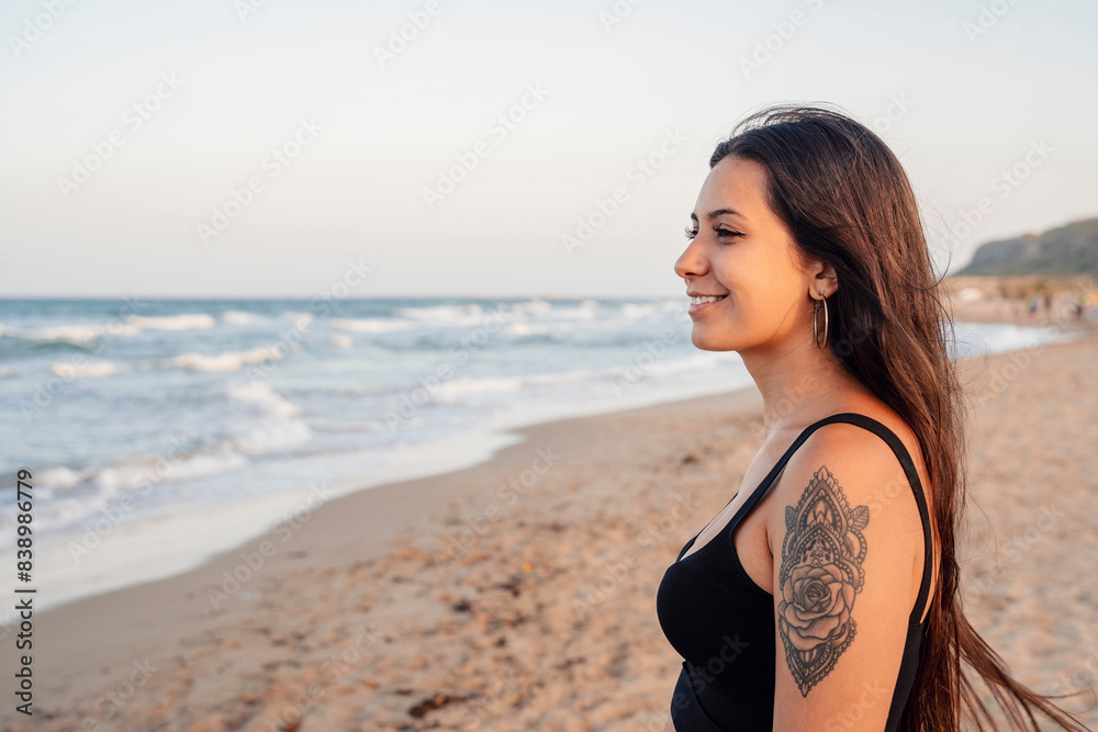 Happy teenage girl standing at beach against clear sky Happy teenage girl standing at beach against clear sky
