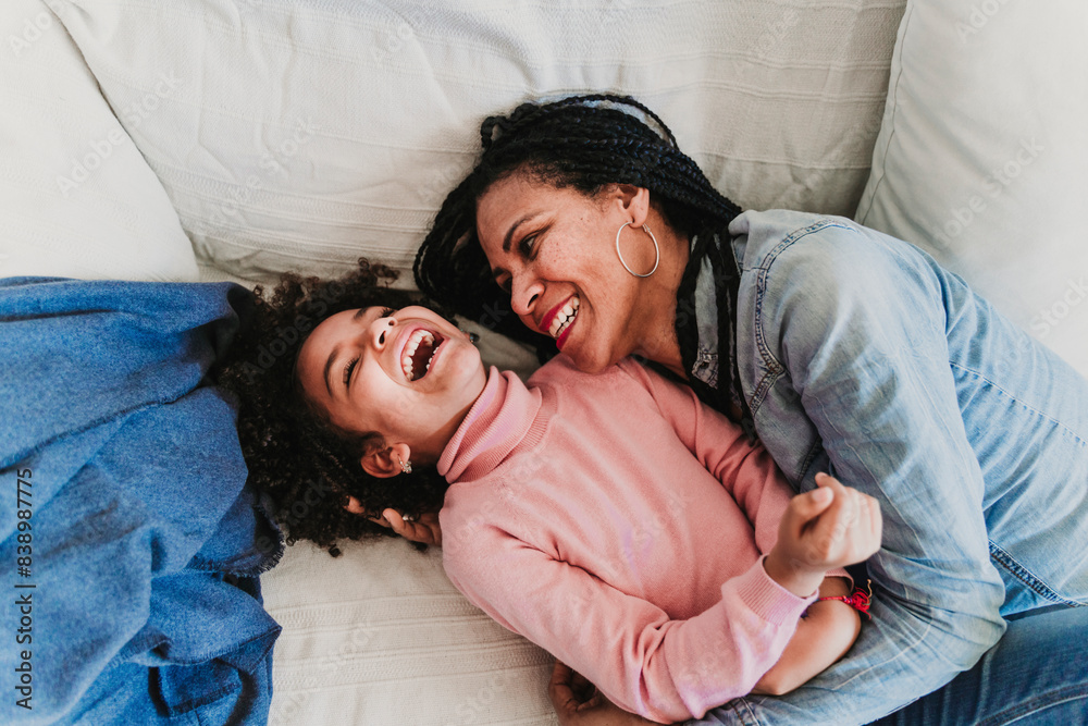 Mother and little daughter on the couch at home having fun Mother and little daughter on the couch at home having fun