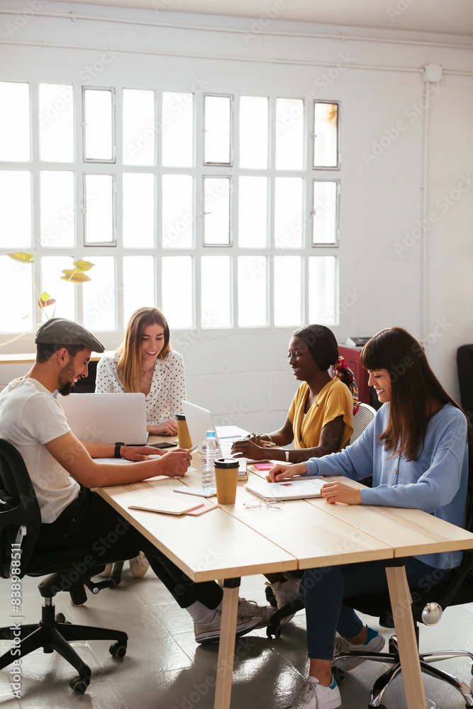 Smiling colleagues working together at desk in office Smiling colleagues working together at desk in office