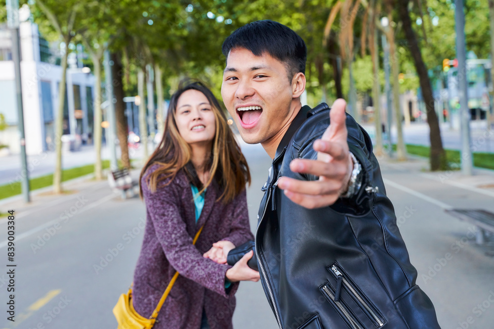 Fototapeta premium Happy couple inviting someone to join them for a walk, Barcelona, Spain