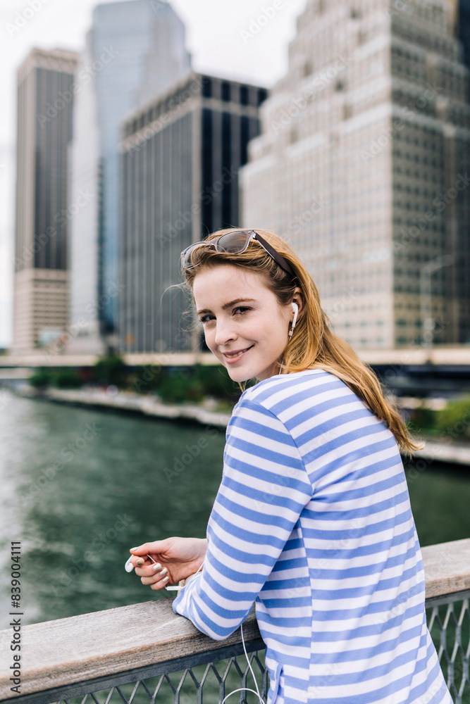 USA, New York City, Young woman standing in Manhattan, looking at camera