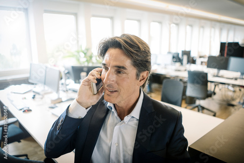 Businessman in office on cell phone
