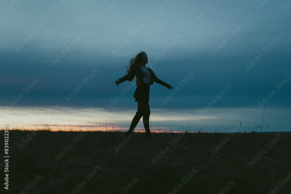 Silhouette of woman on a meadow at sunset Silhouette of woman on a meadow at sunset