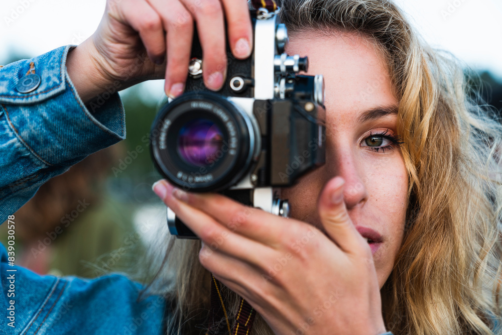 Close-up of beautiful blond young woman taking a picture with a camera Close-up of beautiful blond young woman taking a picture with a camera