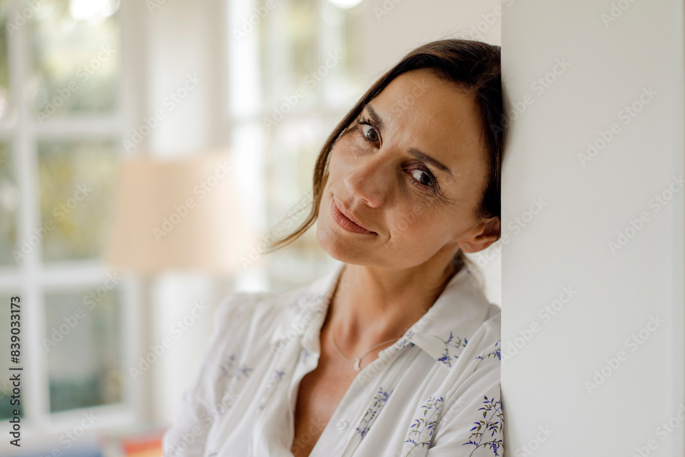 Portrait of mature woman leaning against doorframe Portrait of mature woman leaning against doorframe
