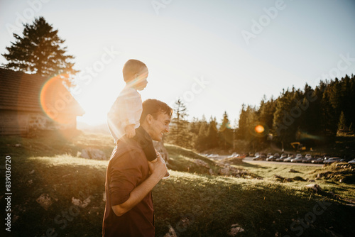 Father carrying little son on shoulders on a hiking trip at sunset, Schwaegalp, Nesslau, Switzerland photo