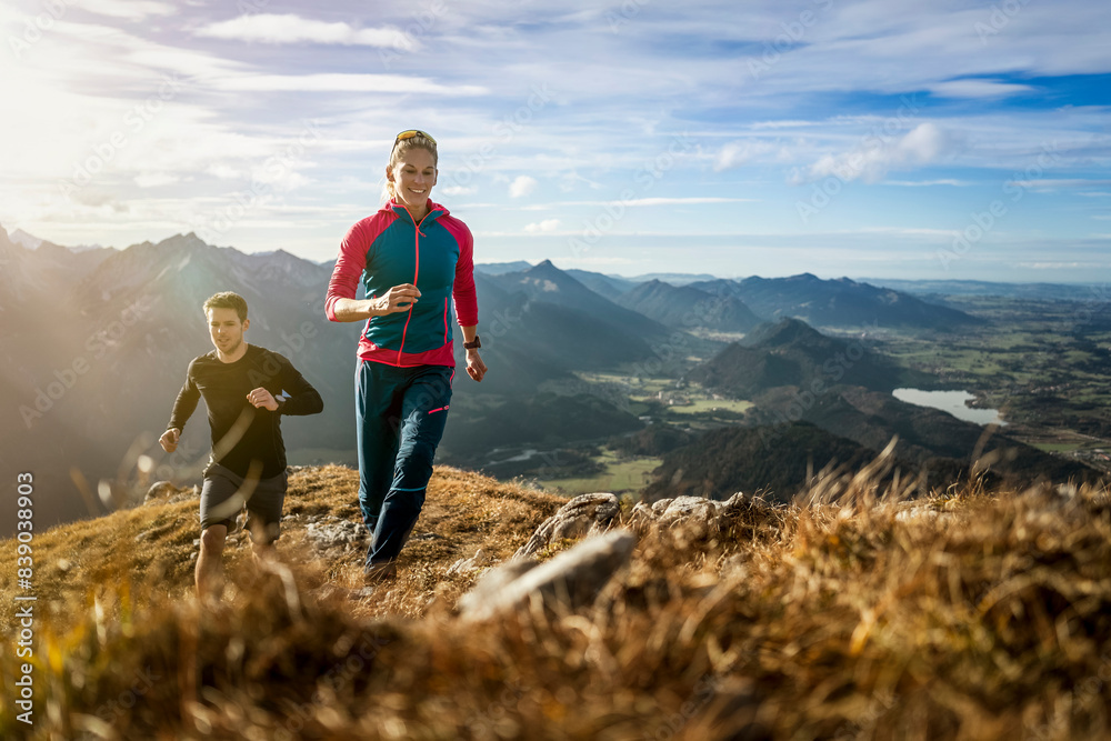 Sports people practicing trail running on mountain path of Saulingspitze at Bavaria, Germany Sports people practicing trail running on mountain path of Saulingspitze at Bavaria, Germany