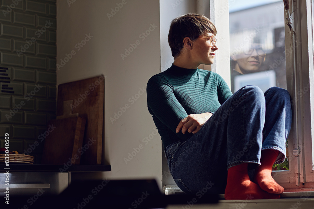 Pensive woman at home looking out of window Pensive woman at home looking out of window