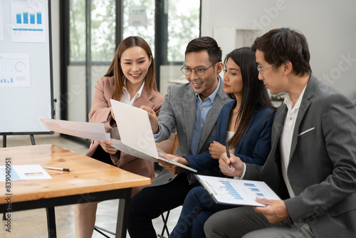 Asian business group discussing graph work at the office