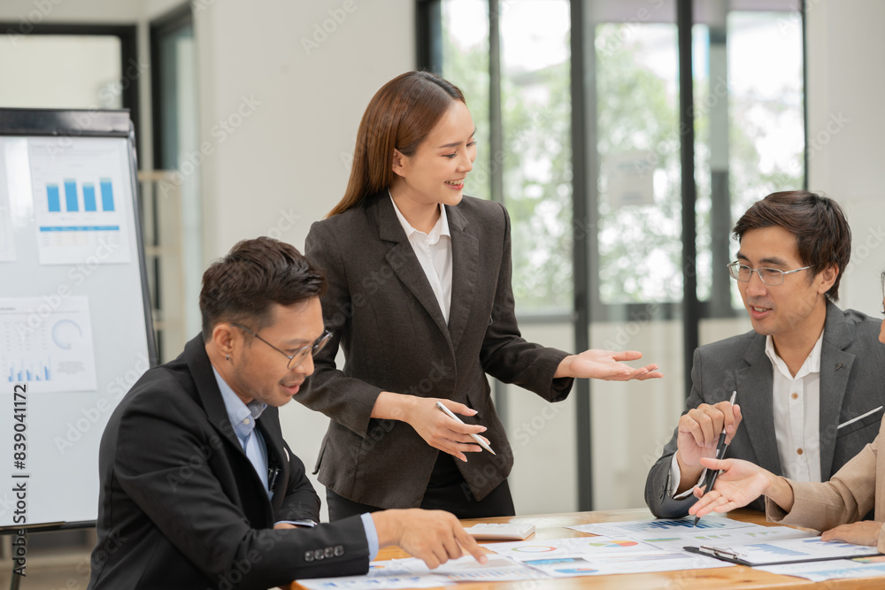 Group of Asian businessmen are presenting graphs on a whiteboard. Group of Asian businessmen are presenting graphs on a whiteboard.
