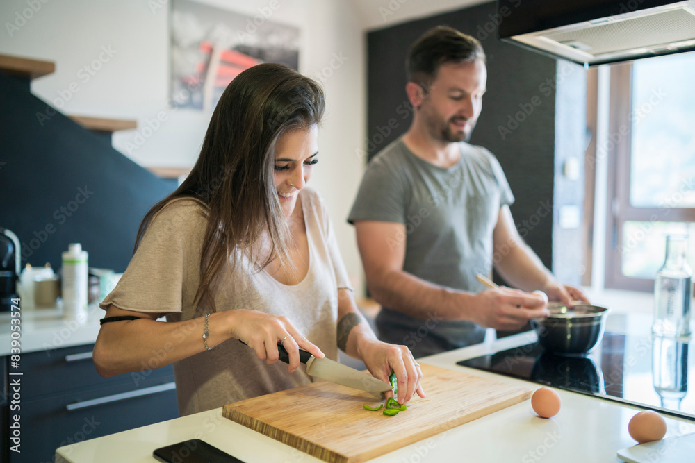Couple preparing food on kitchen island at home Couple preparing food on kitchen island at home