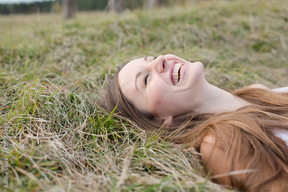 Laughing young woman lying on a meadow Laughing young woman lying on a meadow