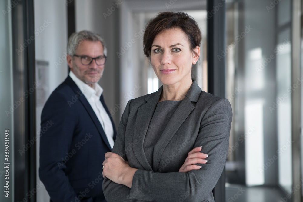 Portrait of confident businesswoman with businessman in background Portrait of confident businesswoman with businessman in background