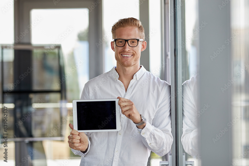 Portrait of smiling businessman showing tablet at the window in office Portrait of smiling businessman showing tablet at the window in office