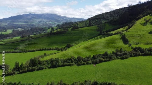 Aerial Drone Panning Over Lush Green Terraced Farmland On Foothills of the Pasochoa volcano, Puichig neighborhood, showing the Machachi valley, Cantón Mejía, Pichincha Province, Ecuador photo