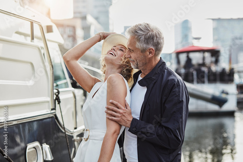 Older man and young woman at a marina next to a yacht