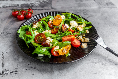 Plate of lowcarbvegetarian salad with arugula, tomatoes, nuts and Mozzarella cheese