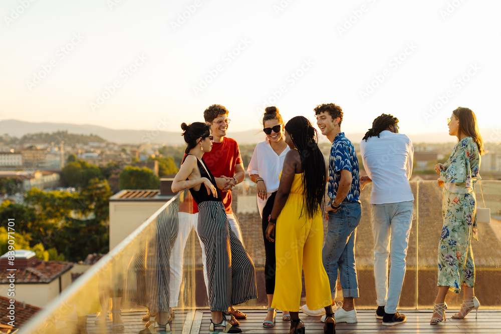 Group of happy multi-ethnic friends celebrating a party in the evening