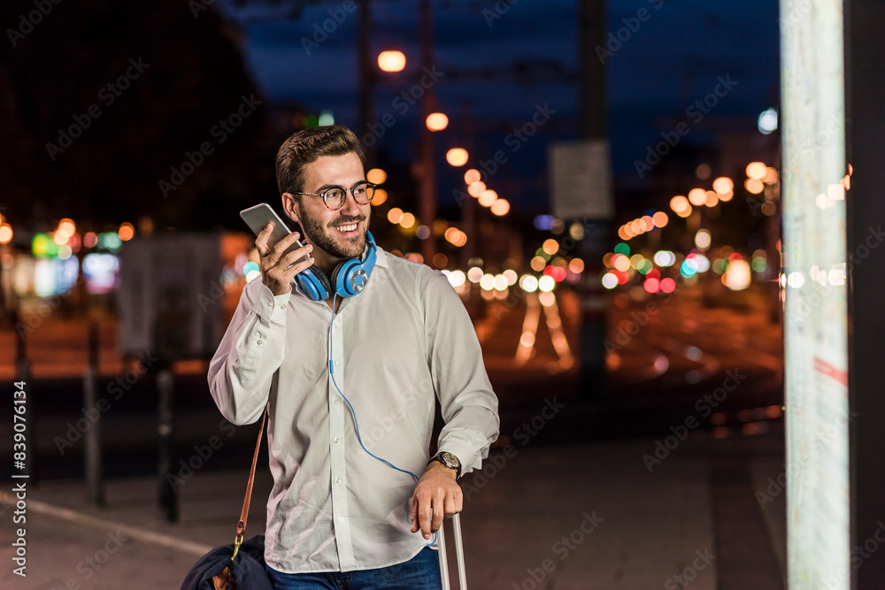 Young man in the city with headphones and cell phone at night Young man in the city with headphones and cell phone at night