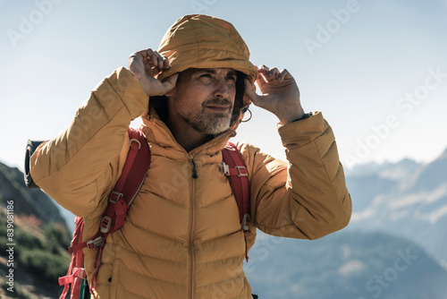 Austria, Tyrol, portrait of man with hooded jacket on a hiking trip in the mountains photo