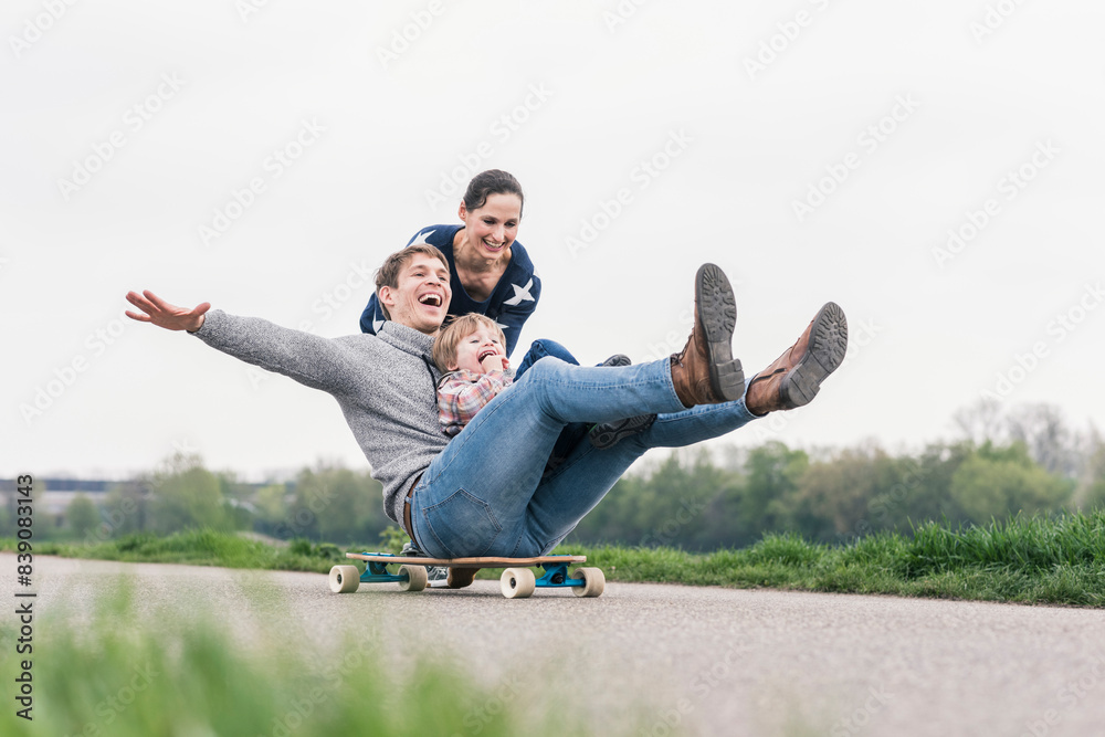 Father and son having fun, playing with skateboard outdoors Father and son having fun, playing with skateboard outdoors