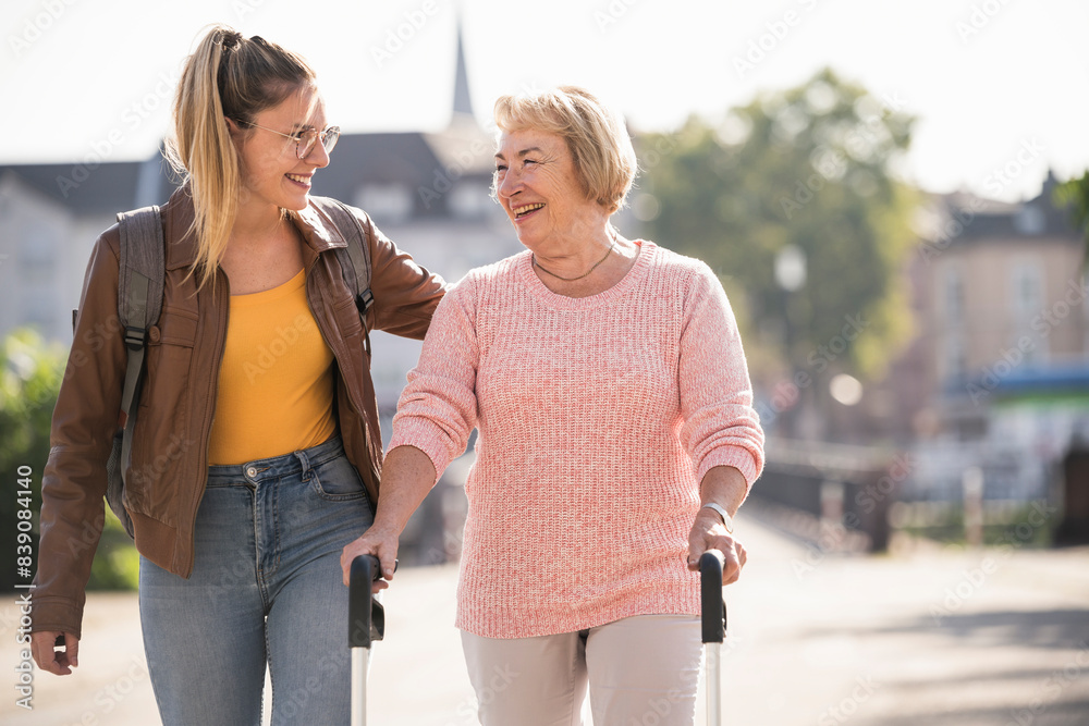 Granddaughter assisting her grandmother walking with wheeled walker