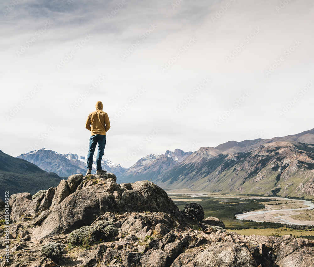 Mature man wearing hood looking at mountains against sky while standing on rock, Patagonia, Argentina Mature man wearing hood looking at mountains against sky while standing on rock, Patagonia, Argentina