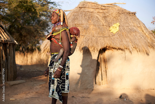 Muhila tribe woman carrying her child on her back, Kehamba, Chibia, Angola photo