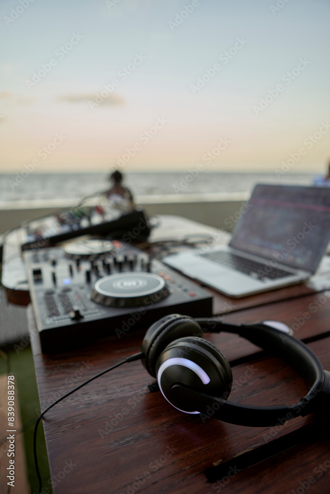 Headphones lying on table in front of mixing board Headphones lying on table in front of mixing board