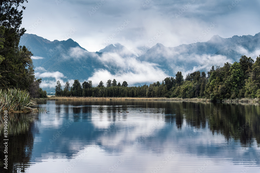 Lake Matheson glacier lake with mountain range and foggy reflection at New Zealand Lake Matheson glacier lake with mountain range and foggy reflection at New Zealand