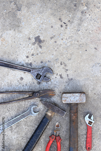 Old working tools on a concrete surface, top view. Hammers, sledgehammer, metal shears, adjustable wrench and wrench. Hand tool. Builder's Day or Father's Day. Construction and renovation concept