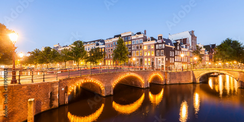 Netherlands, Amsterdam, lighted bridges over Emperor's Canal and Leidse Canal in the evening photo
