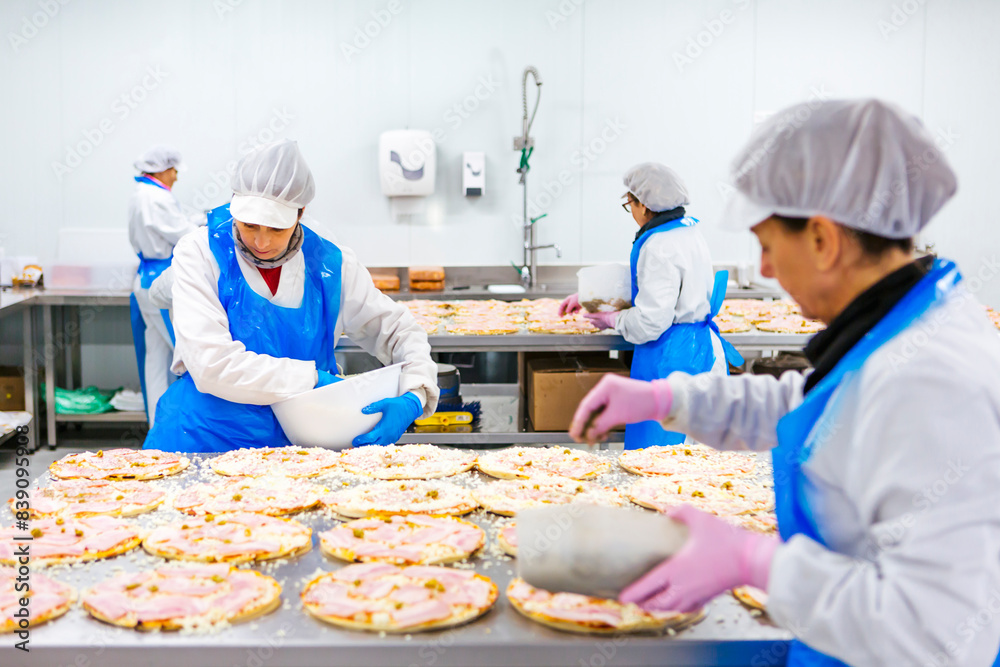 Women preparing pizzas in pizza company