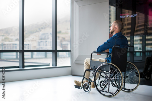 Man in wheelchair looking out of window in office © tunedin