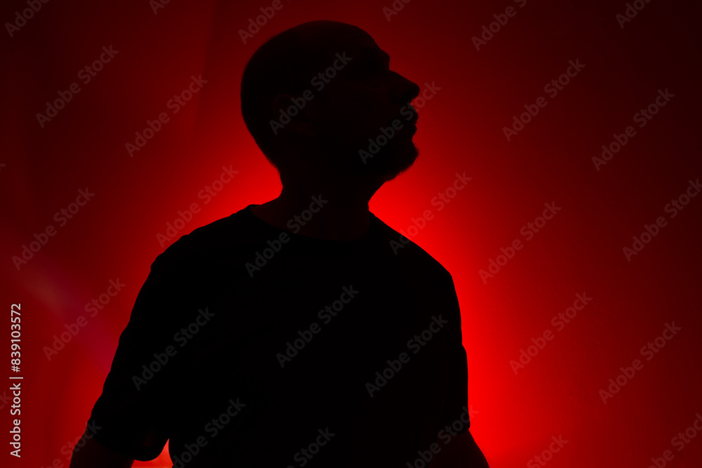 Studio portrait of a man in silhouette, standing still and posing. Studio portrait of a man in silhouette, standing still and posing.