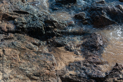 Dark rocks on a beach.