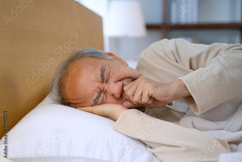 Senior man is sick and sleeping in bedroom.